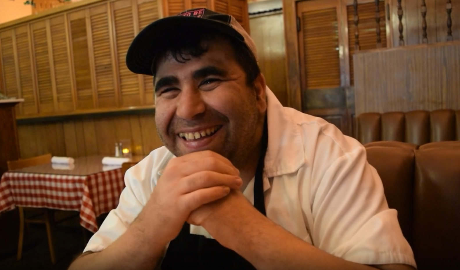 man with hat smiling in restaurant
